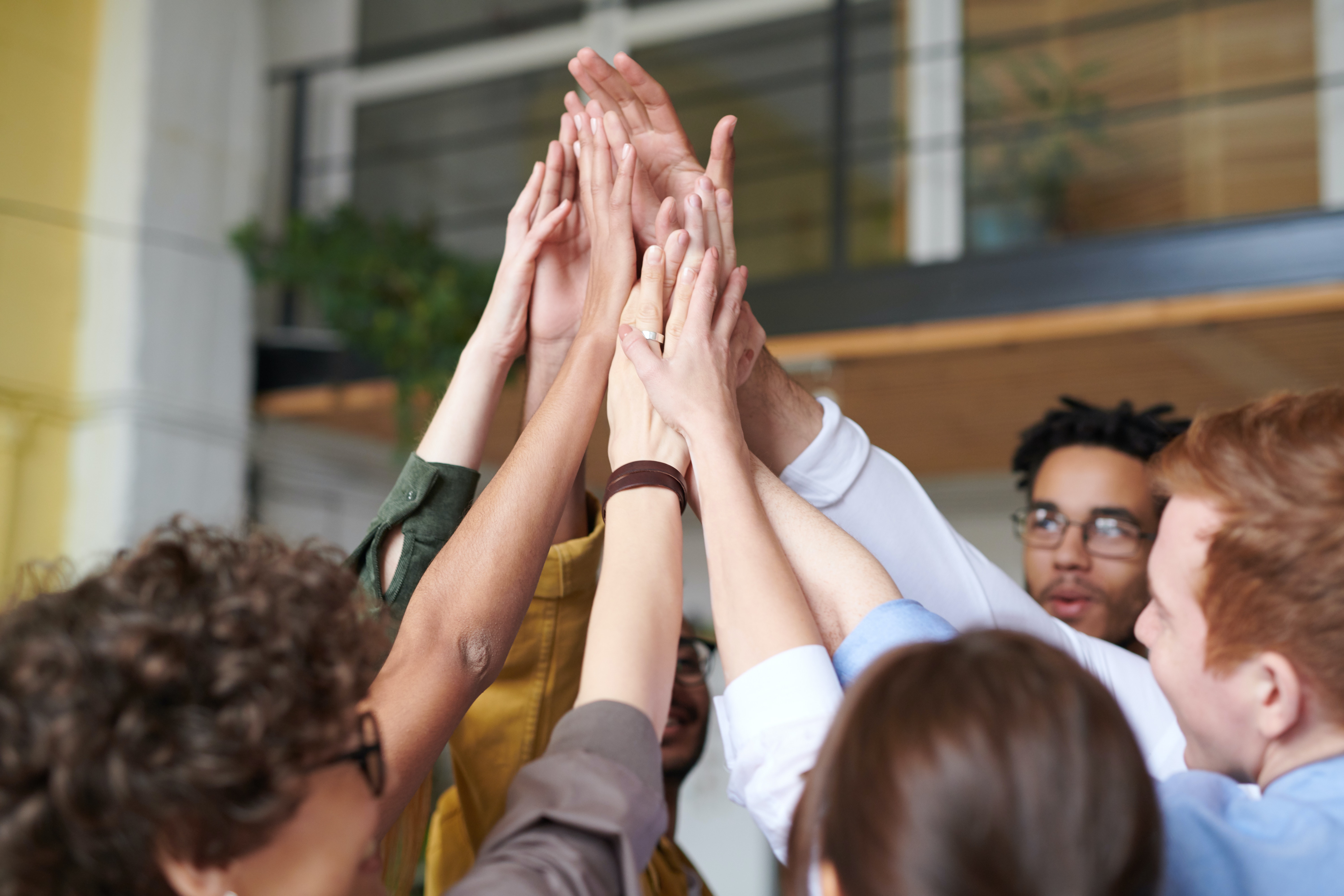 Photo Of People Touching Each Other's Hands in the Air